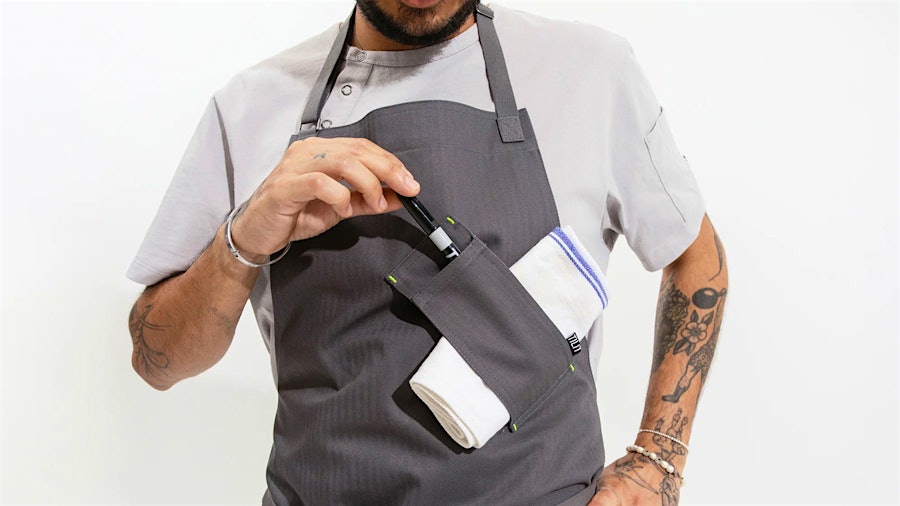 Designed for functionality in the kitchen, the Tilit Utility Apron features spots for towels, pens and more.