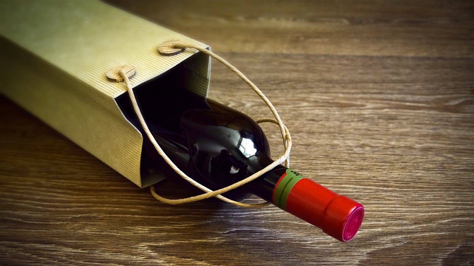 A bottle of wine in a gold gift bag